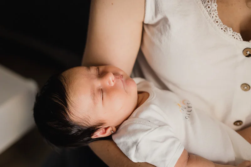 Bebé recién nacido dormido en brazos de su madre en Zaragoza